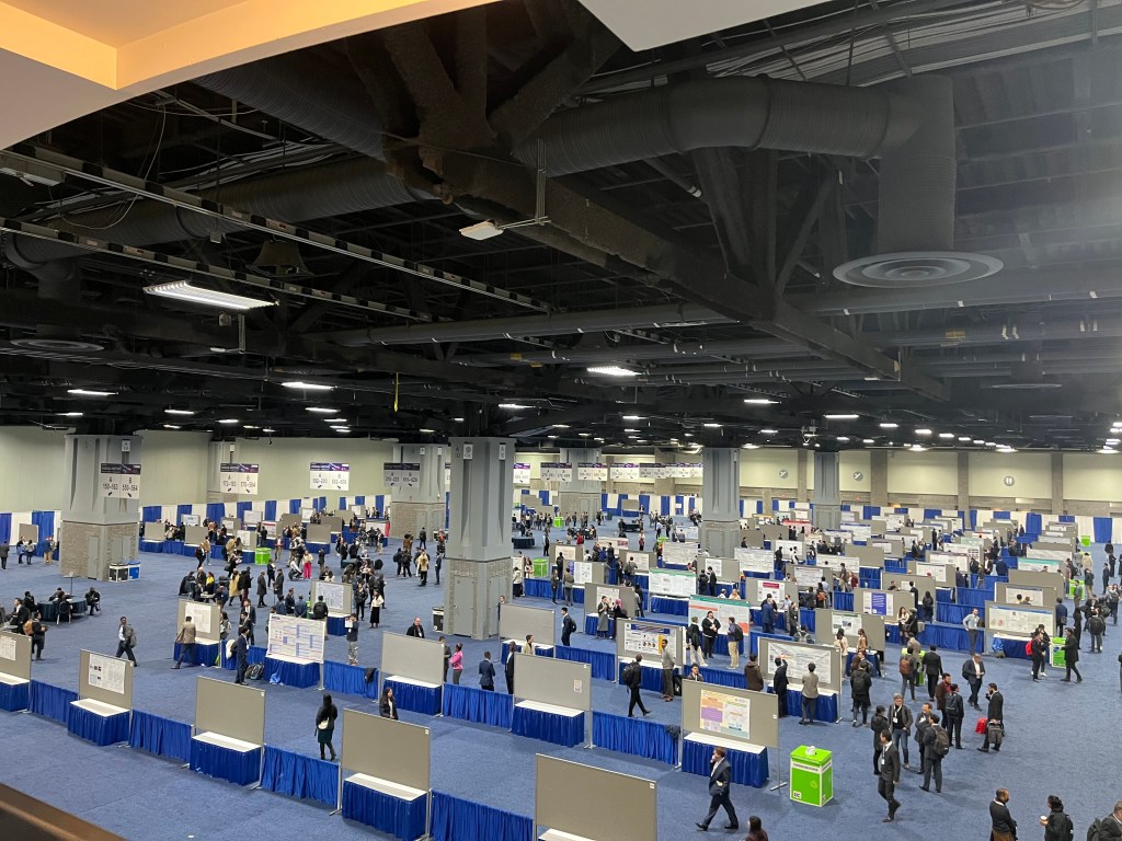 a big hall with posters and lots of people 